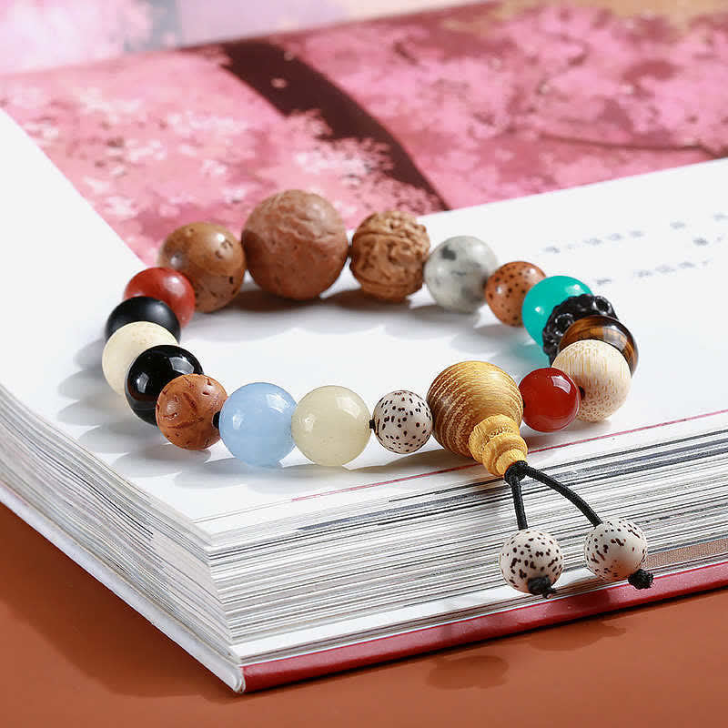 Mala Achat Bodhi Harmonie Armband bunte Perlen auf aufgeschlagenem Buch Flat Lay