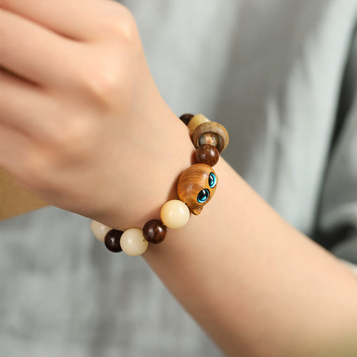 Sandelholz Bodhi Katze Armband am Handgelenk mit braunen und cremefarbenen Perlen getragen