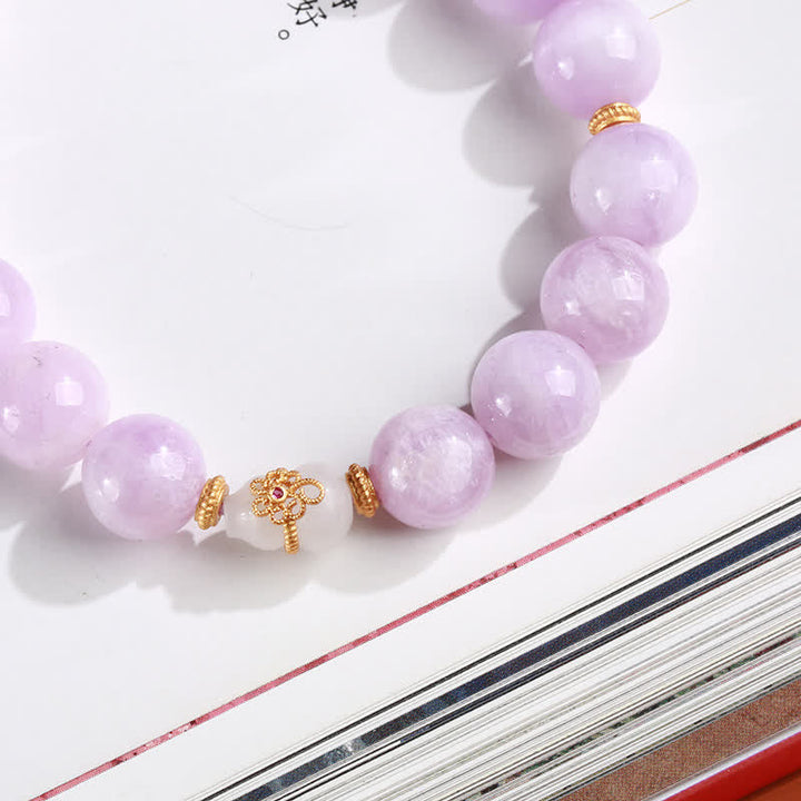 Lavendel Jade Armband mit goldenen Perlen auf weißem Hintergrund