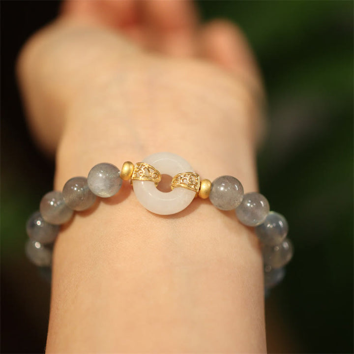 Mondstein Jade Armband mit goldenem Mond-Anhänger am Handgelenk getragen