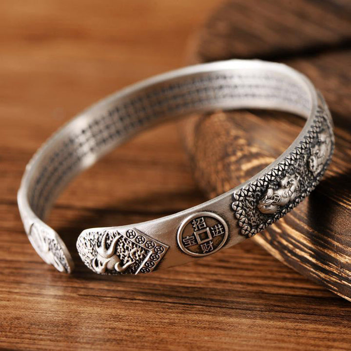 Silber Armband mit Drache und Münze Motiv Holzhintergrund elegant.