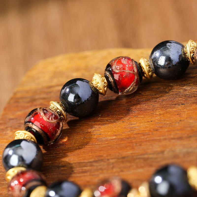 Armband Zakiram Glück Wohlstand schwarze Obsidian rote Perlen Goldakzente