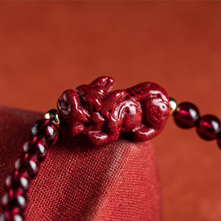 Rotes Armband mit Pixiu-Anhänger und Granat-Perlen am Handgelenk getragen.