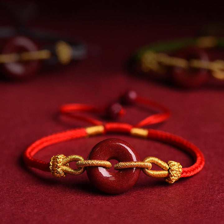 Armband Zinnober – Frieden & Segen Energie rotes Seidenband goldene Verzierungen