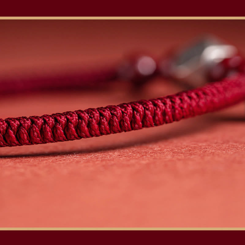 Rotes Armband mit geflochtenem Design auf korallenfarbenem Hintergrund elegantes Accessoire