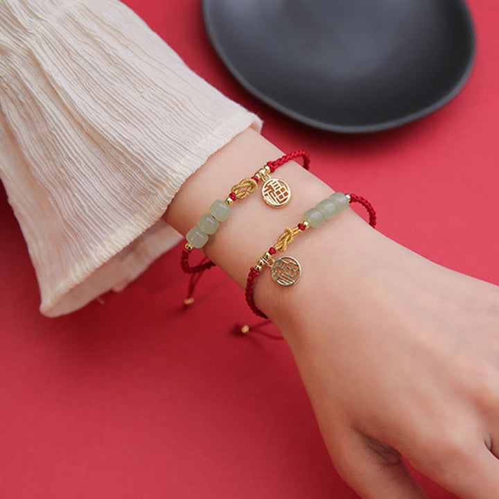 Jade Armband mit Fu-Zeichen Charm am Handgelenk, rotes Stoffband, Glück Balance.