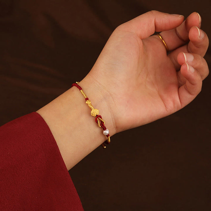Armband Perle Fu-Zeichen Glück goldfarben rotes Textil Handgelenk