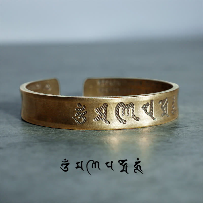 Goldenes Tibet Buddha Mantra Armband Nahaufnahme flach auf grauem Untergrund