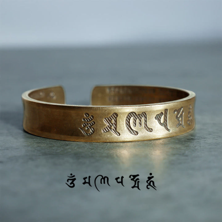 Goldenes Tibet Buddha Mantra Armband Nahaufnahme flach auf grauem Untergrund