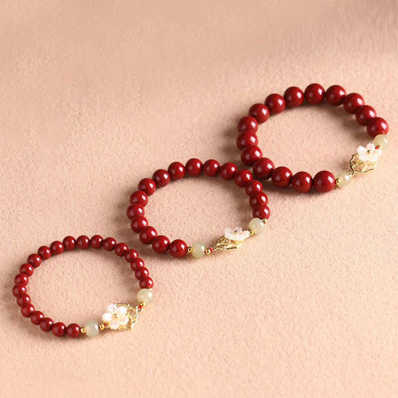 Rotes Zinnober Jade Armband mit weißen Blüten Charms elegant.