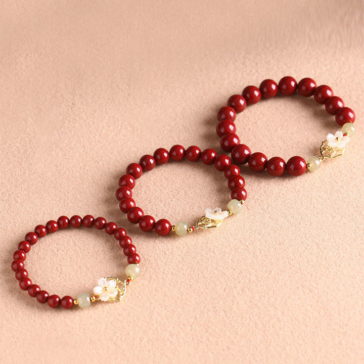 Rotes Zinnober Jade Armband mit weißen Blüten Charms elegant.