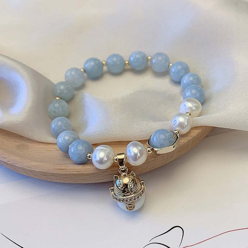 Armband Aquamarin Perle Katze Glück Heilung Holzschale Nahaufnahme blau weiß