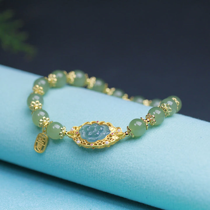 Grünes Jade Armband mit goldenem Lotus-Anhänger elegant präsentiert
