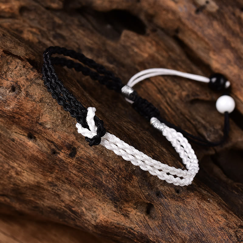 Armband Schwarz Weiß – Heilung geflochtenes Seil Holzhintergrund elegant.