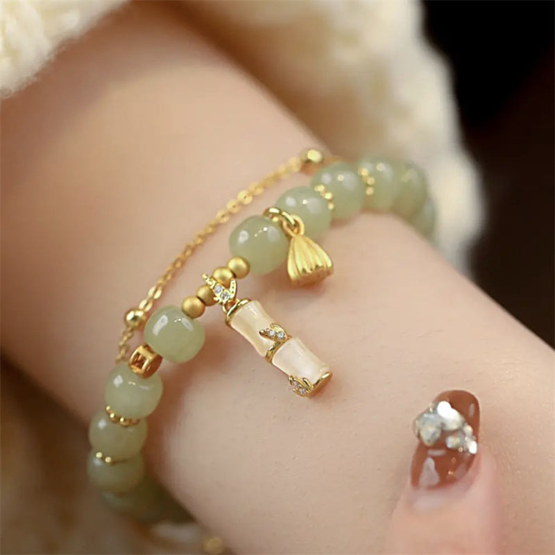 Jade Bambus Armband Armband getragen, grüne Steine mit goldenen Akzenten.