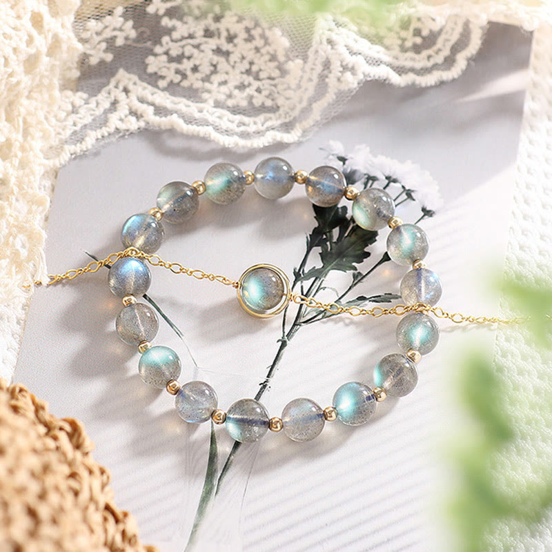 Armband Mondstein mit goldenen Perlen elegant präsentiert Blüten.