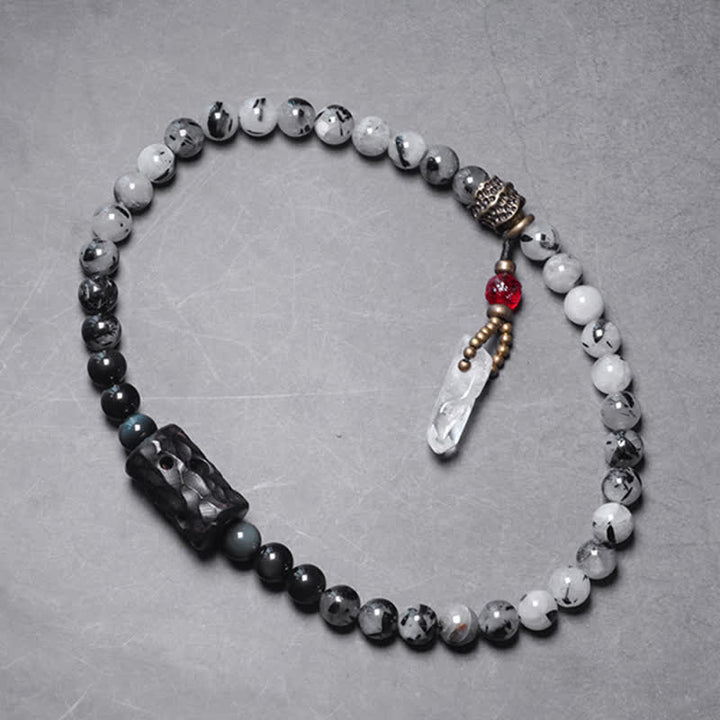 Armband mit weißem Kristall und Ebenholz auf grauem Hintergrund