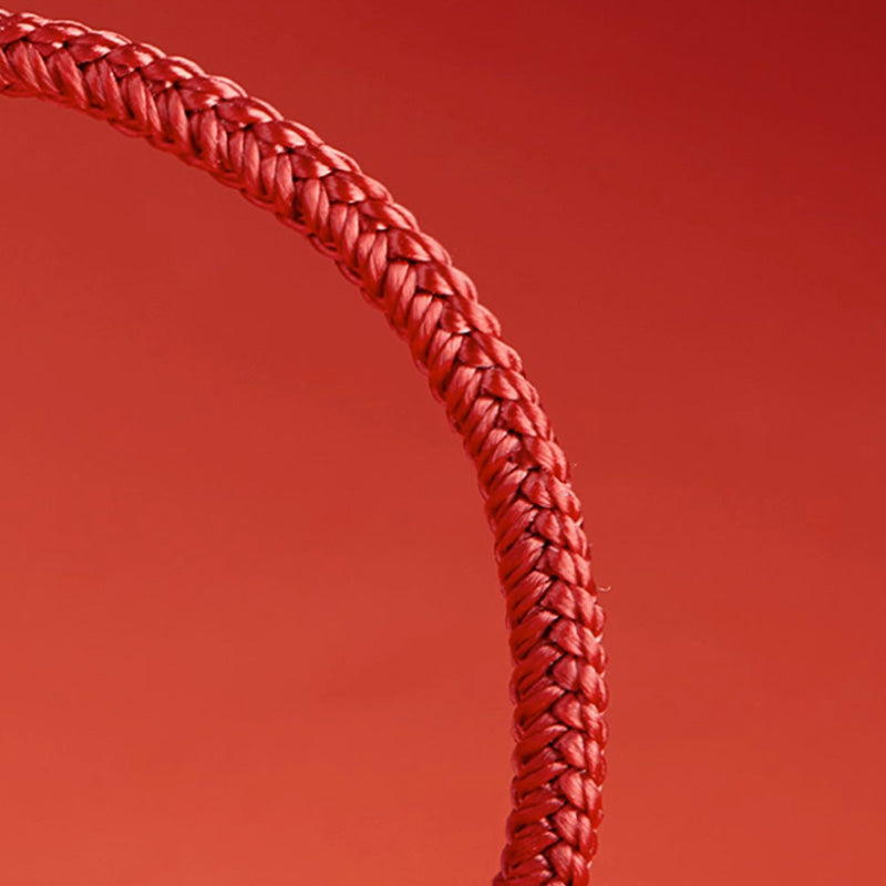 Rotes geflochtenes Armband elastisch am Handgelenk getragen Nahaufnahme