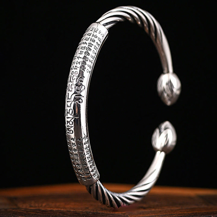 Silbernes Armband Om Mani Padme Hum Herzsutra auf Holz Nahaufnahme