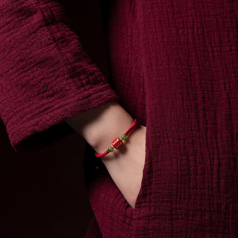Rotes Armband mit Om Mani Padme Hum Perlen am Handgelenk getragen.