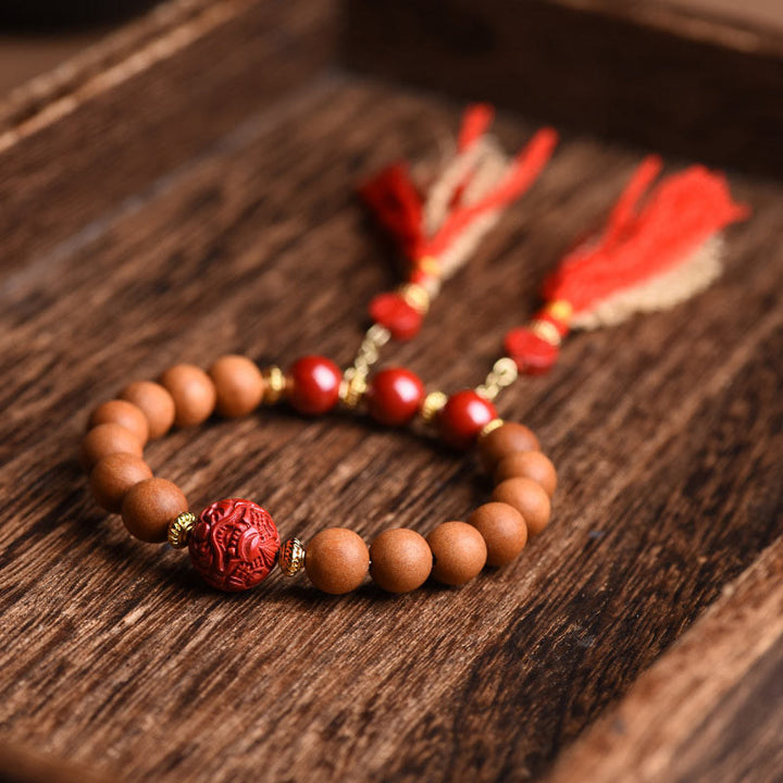 Armband Zinnober Pixiu – Wohlstand mit Holzperlen und roten Quasten.