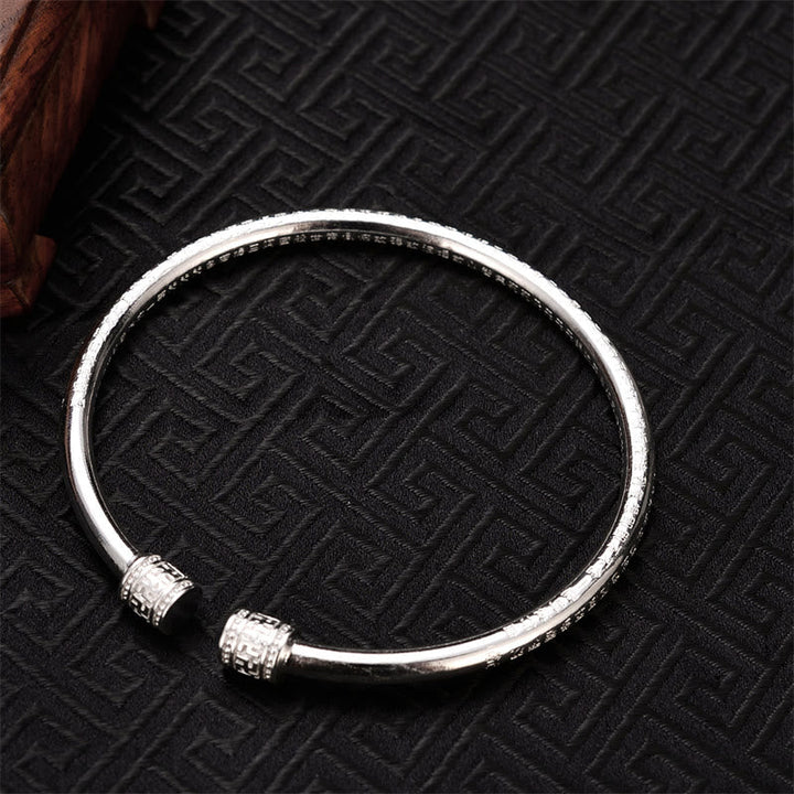 Silbernes Armband mit Herzsutra Gravur auf schwarzem Muster elegant.
