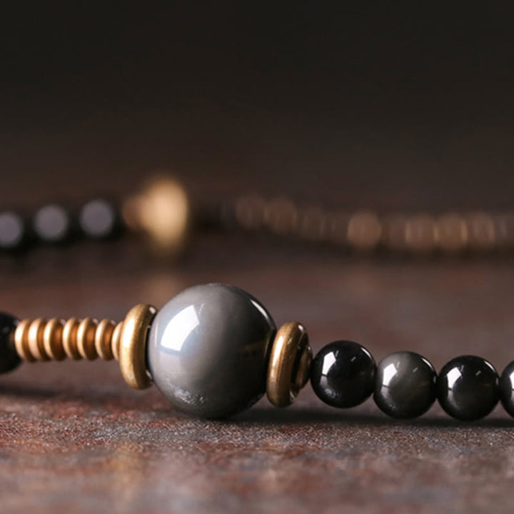 Armband Obsidian Kupfer mit schwarzen Perlen und goldenen Akzenten.