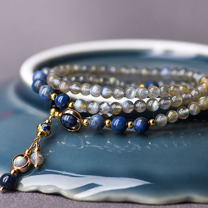 Mondstein Armband mit Lapis Lazuli Perlen auf blauem Untergrund elegant.