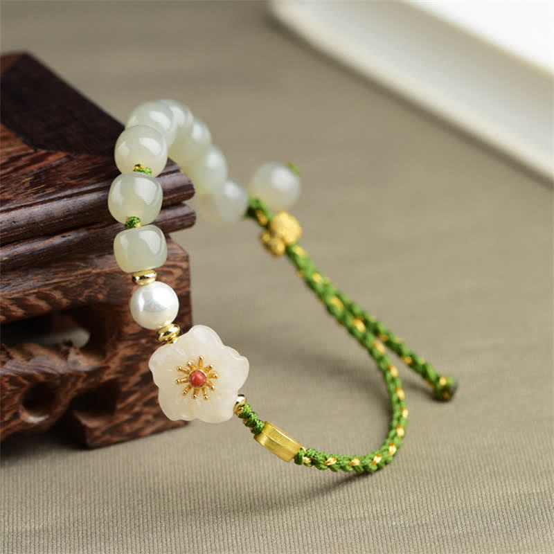 Jade Armband mit Pfirsichblüte Anhänger grünem Seidenband elegante Gestaltung.