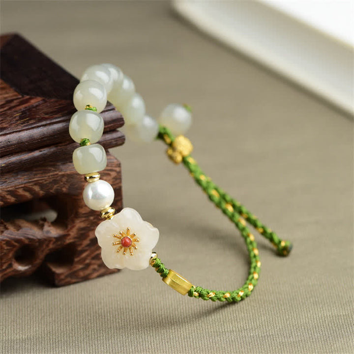 Jade Armband mit Pfirsichblüte Anhänger grünem Seidenband elegante Gestaltung.