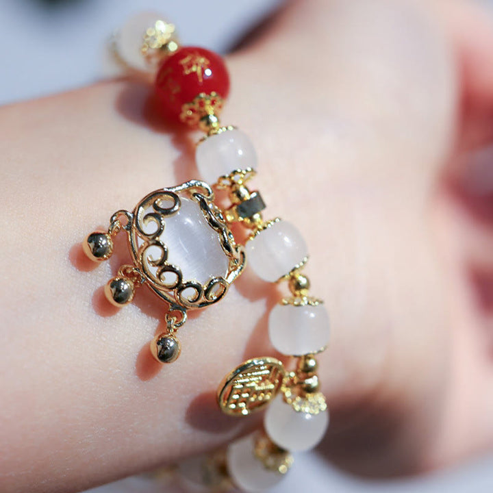 Armband Fu-Zeichen Segen mit weißen Perlen und goldenem Ornament elegant.