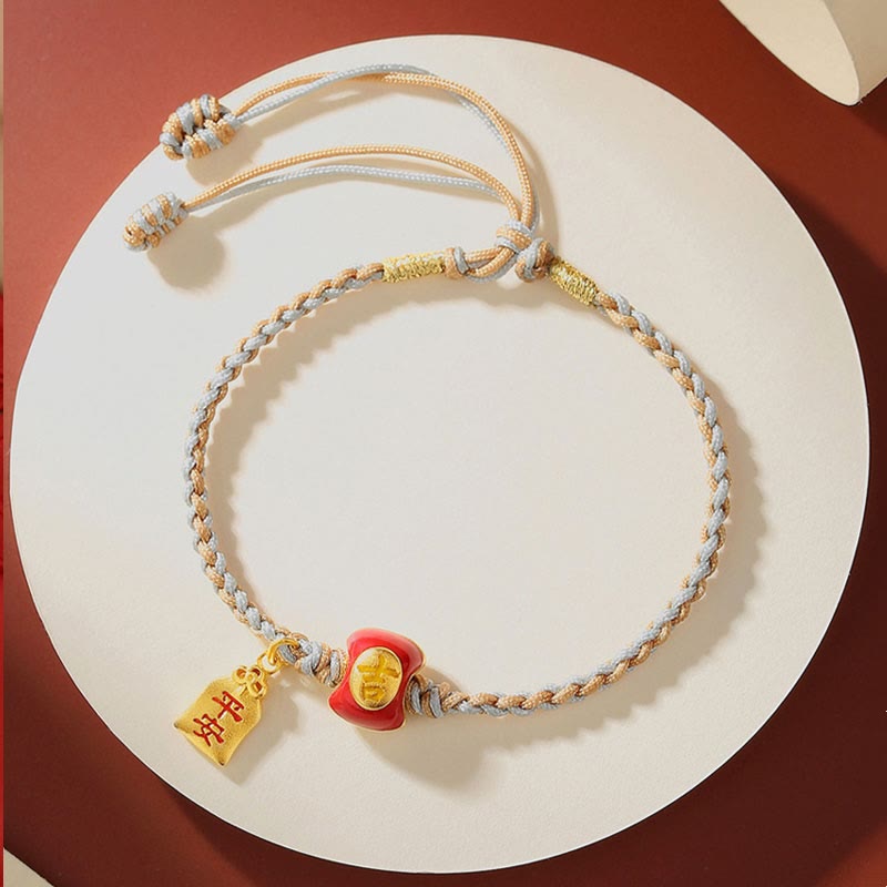 Glücksbringer Armband mit goldenen Charms auf weißem Hintergrund elegant.