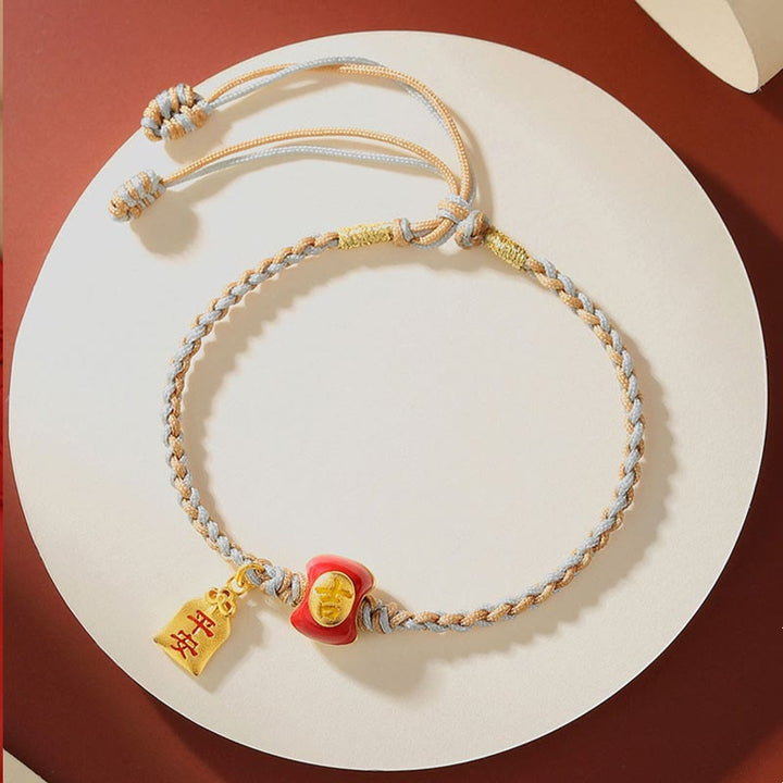 Glücksbringer Armband mit goldenen Charms auf weißem Hintergrund elegant.