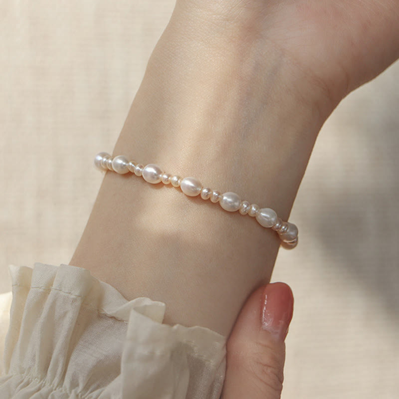 Elegantes Perlenarmband mit weißen Perlen am Handgelenk getragen