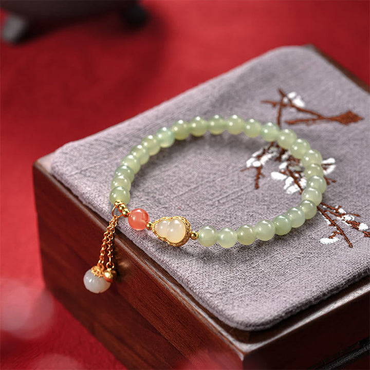 Jade Armband mit Lotus Charm und goldenen Perlen Details elegant.