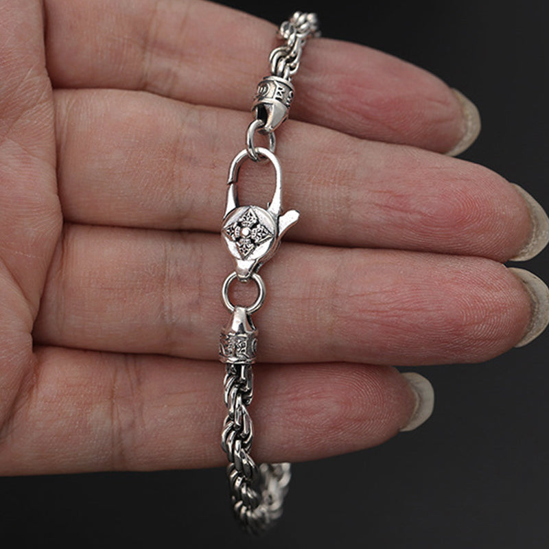 Silbernes Armband mit Om Mani Padme Hum Anhänger am Handgelenk getragen.
