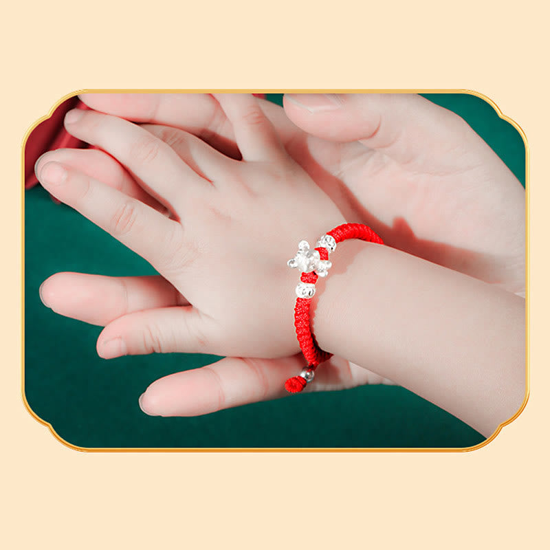 Rotes Armband mit silbernen Perlen am Kinderhandgelenk Glück