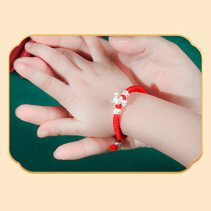 Rotes Armband mit silbernen Perlen am Kinderhandgelenk Glück