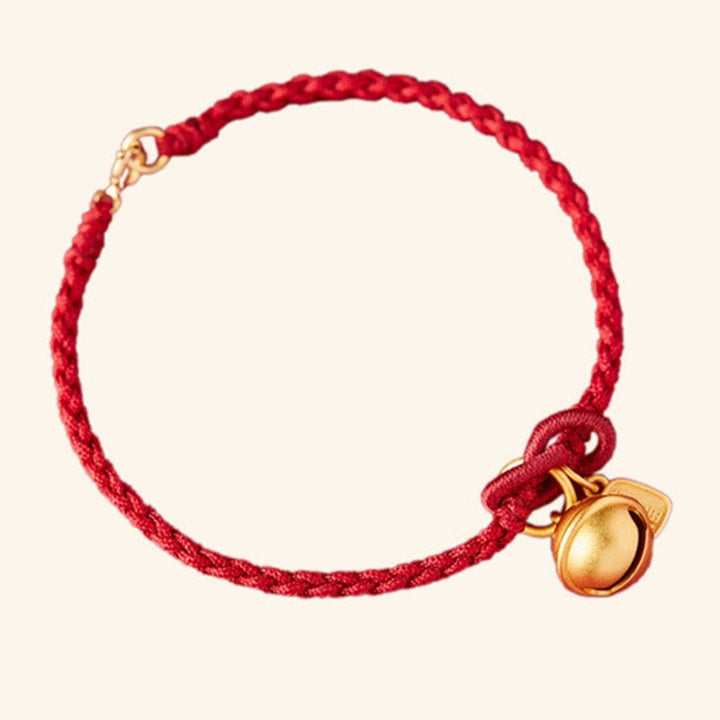 Rotes Armband mit goldenem Glücksbringer Anhänger elegant.