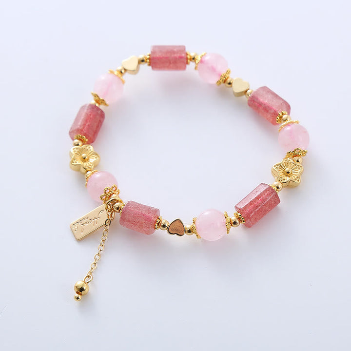 Armband Erdbeerquarz Kristall mit rosa Steinen und goldenen Perlen elegant.