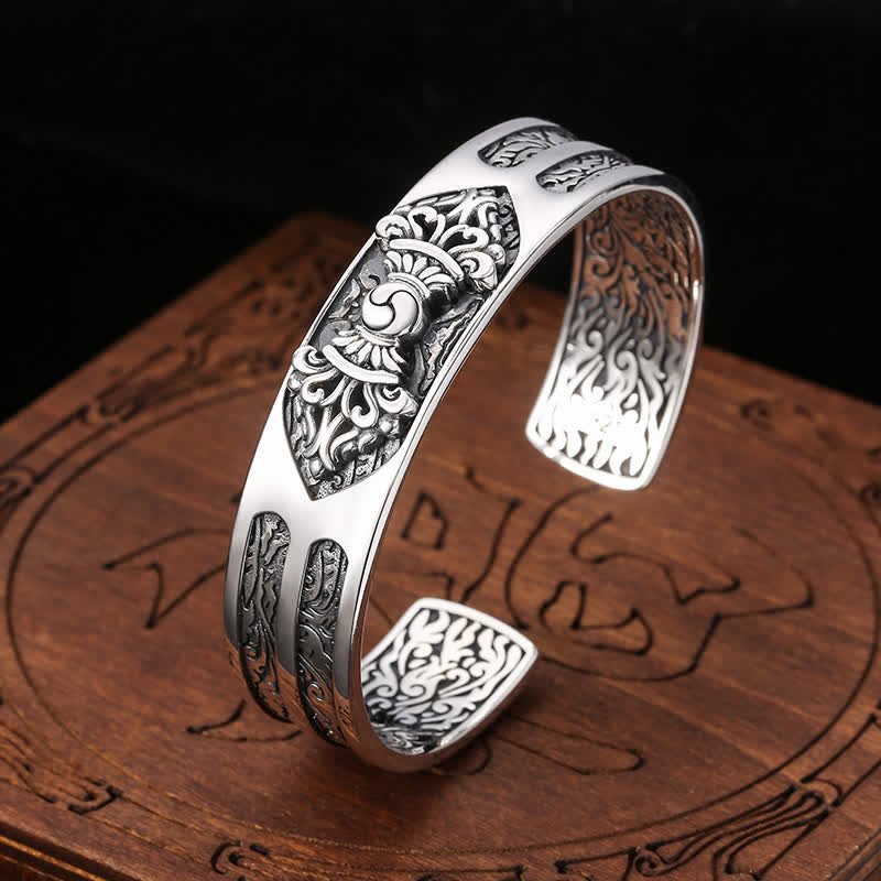 Silbernes Armband 925 mit ornamentalen Mustern auf Holzuntergrund.