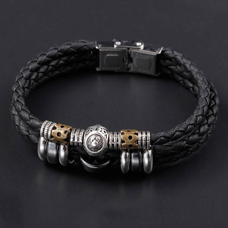 Schwarzes Leder Armband mit Hämatit Tierkreiszeichen Charm auf dunklem Hintergrund
