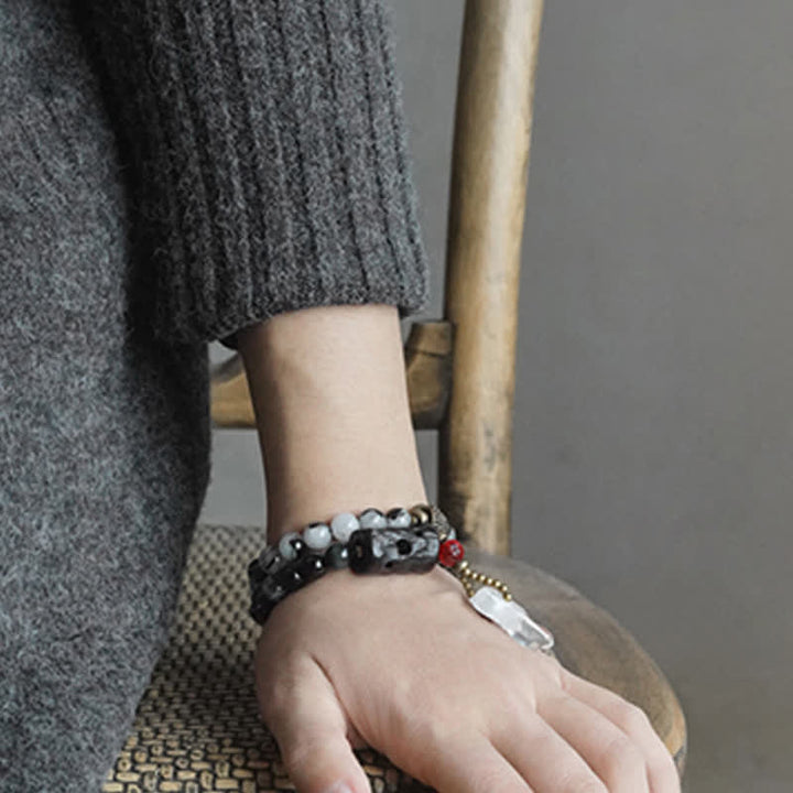 Armband mit weißem Kristall und Ebenholz am Handgelenk getragen.
