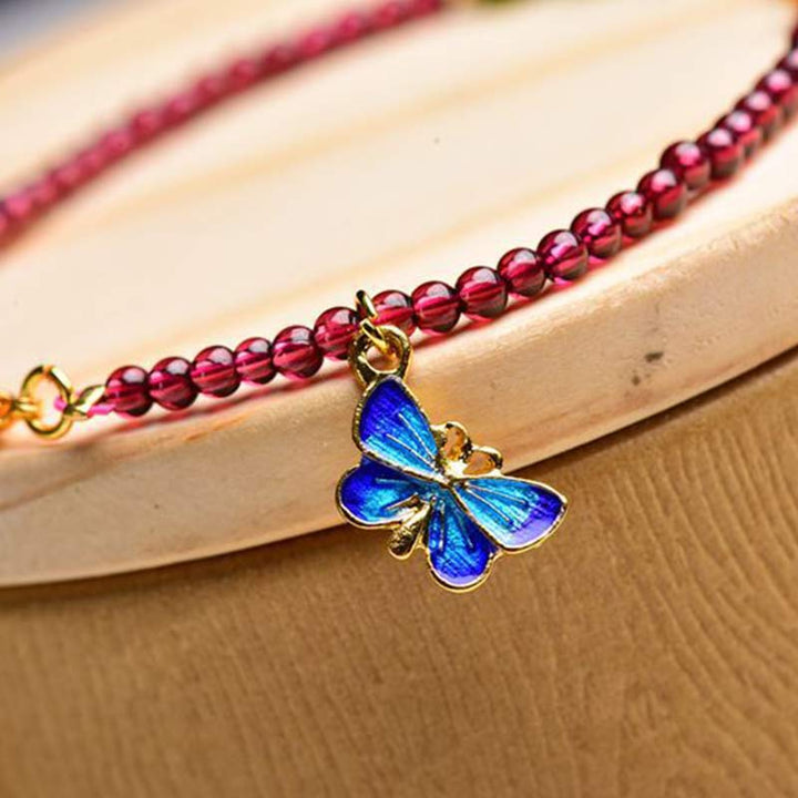 Armband Granat Schmetterling – Schutz mit blauem Schmetterlingscharm elegant.