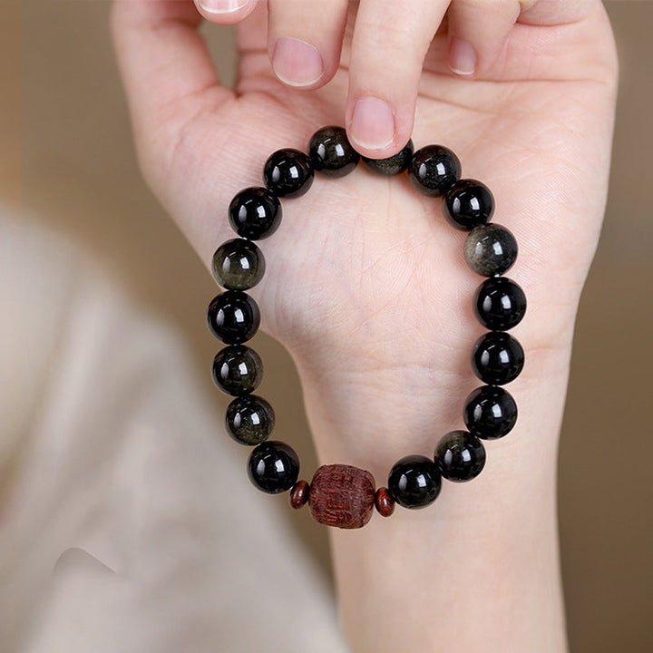 Schwarzes Obsidian Armband mit roten Perlen am Handgelenk getragen