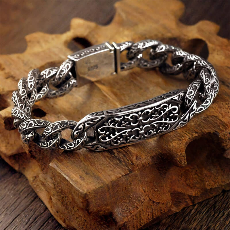 Silbernes Armband mit Ornamenten auf Holzuntergrund, detailliert.