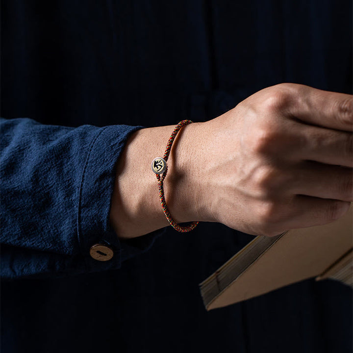 Kupferfarbenes Armband mit Tierkreis-Charm elegant am Handgelenk getragen.