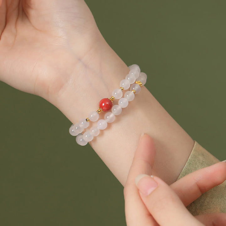 Rosenquarz Armband mit rotem Zinnober Schutzstein elastisch.