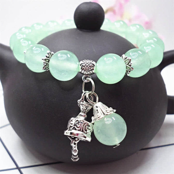 Grünes Kristall Armband Energie auf schwarzem Displayständer elegant.