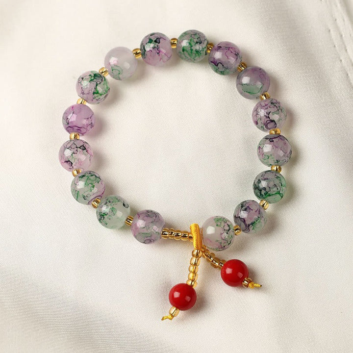 Armband – Harmonie & Segen mit lila grünen Perlen und roten Anhängern